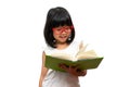 Happy Asian little preschool girl wearing red glasses holding and read a green book on white isolated background. Concept of Royalty Free Stock Photo