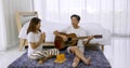 Happy asian lover playing guitar and singing songs together