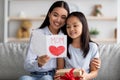 Happy asian loving daughter greeting mom with Mothers Day, young woman holding and reading handmade card Royalty Free Stock Photo