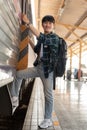 A happy Asian man backpacker is getting on the train, travel somewhere on his summer vacation Royalty Free Stock Photo