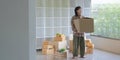 Happy Asian man carrying their belongings upstairs while relocating into new apartment. Royalty Free Stock Photo