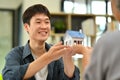 Happy asian man and female holding a house model. Buying property, real estate, loan and insurance concept Royalty Free Stock Photo