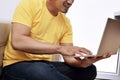 Happy asian man with laptop sitting on the couch Royalty Free Stock Photo