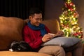 A happy Asian man is reading a book on a couch while his cat is sleeping beside him Royalty Free Stock Photo