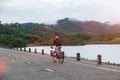 Happy Asian Man Riding Bicycle on Rural Road Look To Nature Ready to Start Vacation Go Adventure Trip, Explore, Discover World Royalty Free Stock Photo