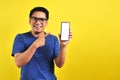 Happy Asian man showing a phone screen and pointing Royalty Free Stock Photo