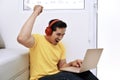 Happy asian man sitting with laptop and headphones Royalty Free Stock Photo