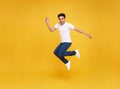 Happy Asian man smiling and jumping while celebrating success isolated over yellow background Royalty Free Stock Photo