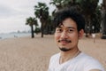 Happy man take selfie with palm tree on the beach. Summer travel concept. Royalty Free Stock Photo