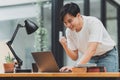 Happy Asian man using laptop computer while have a good news working at office Royalty Free Stock Photo