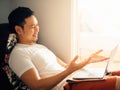 Happy man is using laptop and relax on sofa in the morning. Royalty Free Stock Photo