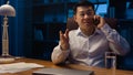 Happy Asian man worker manager executive boss entrepreneur at night office talking mobile phone at desk. Korean Royalty Free Stock Photo