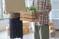 Happy Asian man and her friend carrying their belongings upstairs while relocating into new apartment. Royalty Free Stock Photo