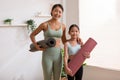 Happy Asian mom and little girl holding yoga mat smile and laughing together ready to exercise yoga at home.2 Healthy mother and Royalty Free Stock Photo