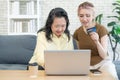 Happy asian mother and cute daughter holding credit card for making online shopping by laptop in living room at home so enjoying Royalty Free Stock Photo