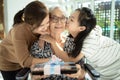 Happy asian mother,daughter meeting old grandparent,giving grandmother a gift,hugging,female elderly hold present box,woman,child