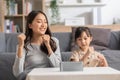 Happy asian mother and daughter sing a song and dancing together watching music video apps in smartphone.Cheerful mom and kid Royalty Free Stock Photo