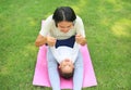 Happy Asian mother playing with her son and lying on green lawn at park Royalty Free Stock Photo