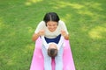 Happy Asian mother playing with her son and lying on green lawn at park Royalty Free Stock Photo