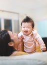 Happy Asian mother plays with baby holding girl in hands, baby smile, Family concept Royalty Free Stock Photo