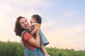Happy Asian mother plays with daughter and holding girl in hands at park with nice sky, Baby smile and laughing, Family concept Royalty Free Stock Photo