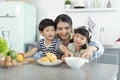 Happy Asian mother with son and daughter in kitchen. Enjoy family activity together Royalty Free Stock Photo