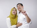 Happy Asian Muslim Couple Dreaming, Pointing and Looking Up Royalty Free Stock Photo
