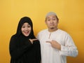 Happy Asian muslim couple proud of each other, pointing and smiling, lovefamily good relationship