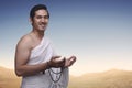 Happy asian muslim man wearing ihram clothes and prayer beads