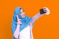 Happy Asian muslim woman taking selfie with smartphone Royalty Free Stock Photo