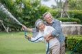 Happy asian old couple watering the plants  in the front lawn at home. senior man and elder woman Spend time together in backyard Royalty Free Stock Photo