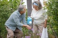 happy asian old couple watering the plants in the front lawn at home. senior man and elder woman Spend time together in backyard Royalty Free Stock Photo