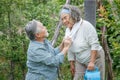 happy asian old couple watering the plants in the front lawn at home. senior man and elder woman Spend time together in backyard Royalty Free Stock Photo