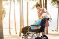 Happy asian old elderly in a wheelchair granddaughter relaxing enjoying on the sea beach together,teenager girl show love,take