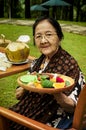 Happy Asian old woman with tray full of food in hand