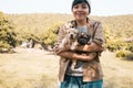 Happy Asian owner carrying, hug adorable puppy dog on her Stand on the grass backyard lawn Royalty Free Stock Photo
