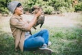 Happy Asian owner carrying, hugging adorable puppy dog on her sitting green grass backyard lawn Royalty Free Stock Photo