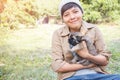 Happy Asian owner carrying, hugging Carrying three adorable  puppies dog her sitting green grass backyard lawn Royalty Free Stock Photo