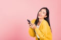 Happy Asian portrait beautiful cute young woman excited laughing holding mobile phone Royalty Free Stock Photo