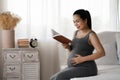 Happy Asian pregnant are reading a book in bedroom Royalty Free Stock Photo