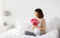 Happy asian pregnant woman with flowers in bed Royalty Free Stock Photo