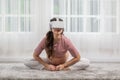 Happy Asian Pregnant woman using virtual reality glasses for practice yoga online class butterfly pose to meditation with big Royalty Free Stock Photo