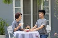 Happy asian retired mother with her adult son are relax talking together at front yard Royalty Free Stock Photo