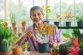 Asian retirement senior is planting tree and flower pot for hobby in his grasshouse Royalty Free Stock Photo