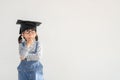 Happy Asian school kid graduate thinking with graduation cap Royalty Free Stock Photo