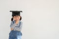 Happy Asian school kid graduate thinking with graduation cap Royalty Free Stock Photo