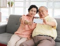 Asian senior couple having good time together,sitting in living room , talking selfie photo or video chatting looking at  smart Royalty Free Stock Photo