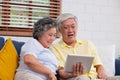 Happy Asian senior couple use tablet video chatting to family at home.aging at home concept Royalty Free Stock Photo