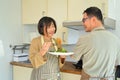 Happy Asian senior couple wearing aprons cooking together at home kitchen. Retirement lifestyle concept. Royalty Free Stock Photo