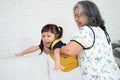 Happy Asian senior grandmother holding and playing with granddaughter in the living room, happy grandma wearing glasses and Royalty Free Stock Photo